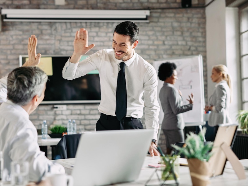 Ein Mann gibt einen anderen Mann ein High 5 Handschlag